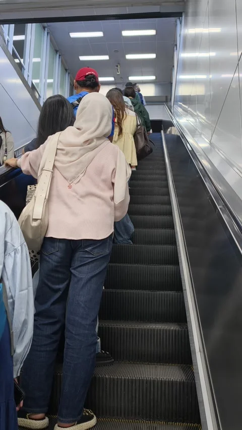 Commuters Riding an Escalator to Exit Jakarta MRT Station Toward the City Street Stock Footage 338316774