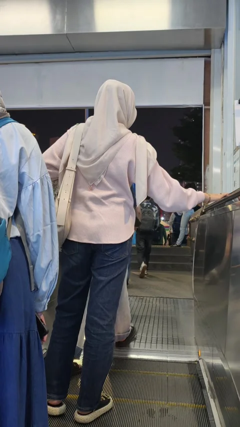 Commuters Riding an Escalator to Exit Jakarta MRT Station Toward the City Street Stock Footage 338316812