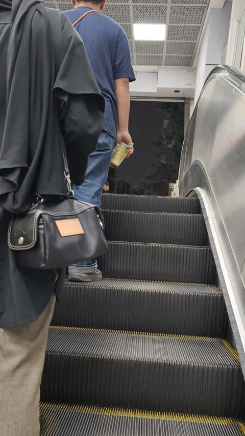 Commuters Riding an Escalator to Exit Jakarta MRT Station Toward the City Street Stock Footage 338316864