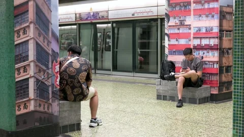 Commuters Sit on Bench as Trains Arrive at Subway Station in Hong Kong, China Stock Footage 294866204