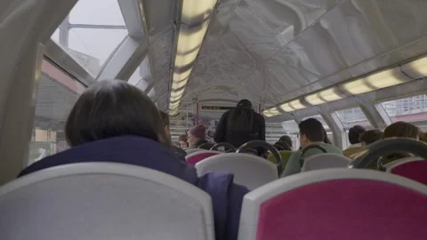 Commuters sit quietly in a Paris double-decker train, seen from the upper level Stock Footage 305757247
