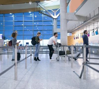 Commuters standing in queue for check-in Stock Photos