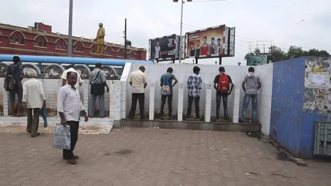 Commuters urinate at a public urinal Stock Footage 77445038