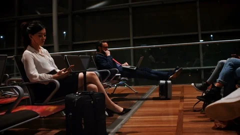 Commuters using mobile phone and laptop in waiting area 4k Stock Footage 93647561