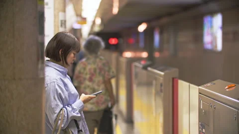 Commuters using smartphone in underground subway train station of Tokyo Metro du Stock Footage 244057585