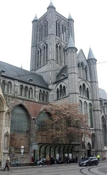 Commuters wait at the bus stop in front of a church Stock Photos