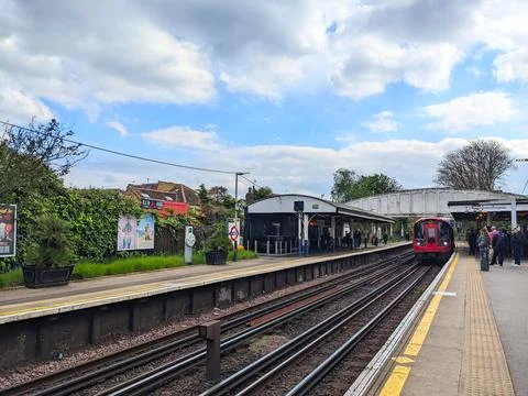 Commuters wait as a London Underground train arrives at Kew Garden Station under Stock Photos