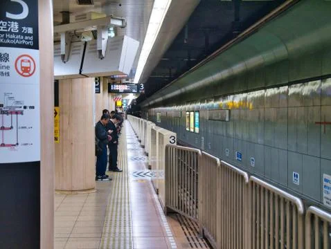 Commuters wait at a subway / underground at a station in Fukuoka, Japan. Stock Photos