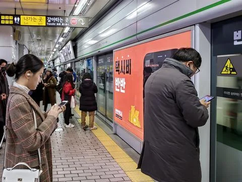 Commuters waiting and queueing at the platform Stock Photos