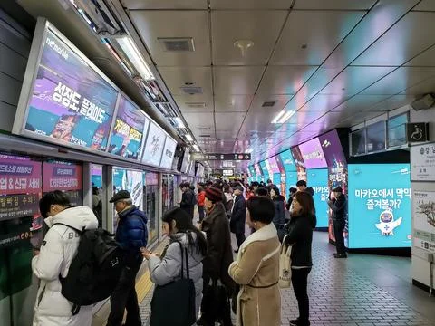 Commuters waiting and queueing at the platform Stock Photos