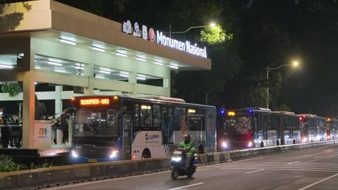 Commuters Waiting at Bus Shelter During Daily Urban Commute at Night Stock Footage 338986593