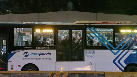 Commuters Waiting at Bus Shelter During Daily Urban Commute at Night Stock Footage 338987906
