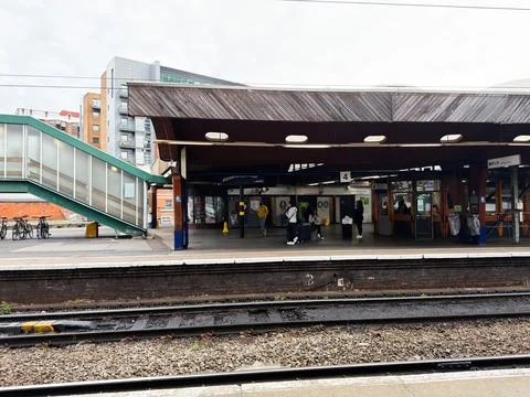 Commuters waiting on a covered train platform at Manchester UK station with.. Stock Photos