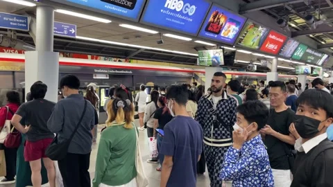 Commuters waiting to get on BTS sky train at Siam station rush hour, Bangkok Stock Footage 231798674
