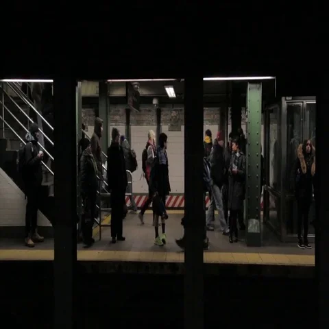 Commuters waiting on platform and train passing in speed at underground station Stock Footage