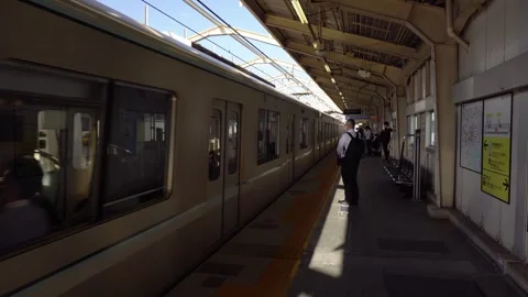 Commuters Waiting on Platform as Local Train Approaches Station in Tokyo, Japan Stock Footage 269153995