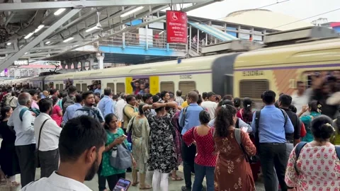 Commuters waiting for a suburban train on a crowded platform in Mumbai, India Stock Footage 341455717