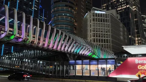 Commuters Walk Across an Elevated Pedestrian Bridge to Bus Shelter Stock Footage 339146274
