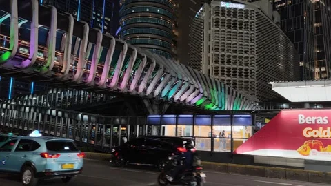 Commuters Walk Across an Elevated Pedestrian Bridge to Bus Shelter Stock Footage 339146384