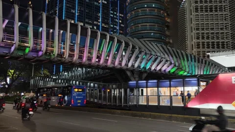 Commuters Walk Across an Elevated Pedestrian Bridge to Bus Shelter Stock Footage 339147957