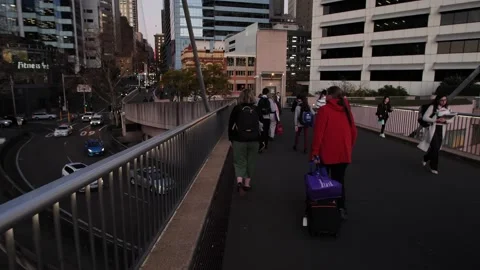 Commuters walk towards Sydney CBD and past evening traffic slow motion 4K Stock Footage 221982068