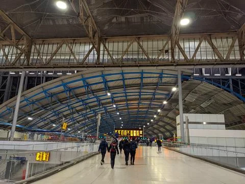 Commuters walking beneath the iconic modern arched roof of Waterloo Railway Stock Photos