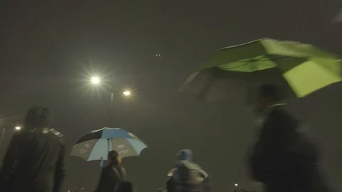 Commuters walking in the rain at night Video stock 118271677