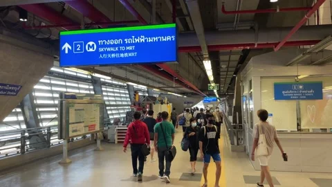 Commuters walking at skywalk MRT train station, interchange to Airport Rail Link Stock Footage 183541565