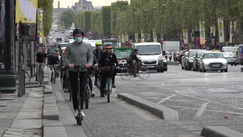 Commuting bicycle riders (some with face masks) in rush hour Paris France Stock Footage 139764161