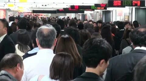 Commuting passengers walk through busy train station at rush hour in Tokyo Video stock 20463451