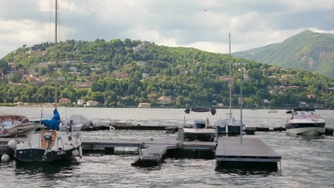 Como, Italy - May 7, 2026: Boats gently rocking while moored to a floating pier Stock Footage 339469659