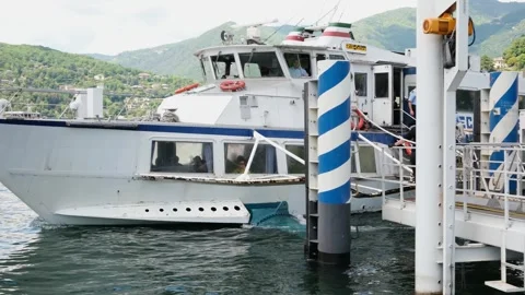 Como, Italy - May 7, 2026: Passenger boat arriving at Lake Como pier. Crew on Stock Footage 339469665