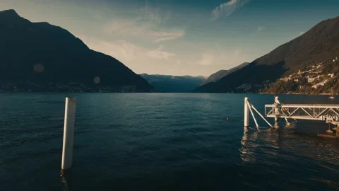 Como lake with two men diving in the water and mountain in the background Video stock 139268940