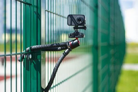 Compact action camera on a flexible tripod. Outdoor travel equipment. Stock Photos