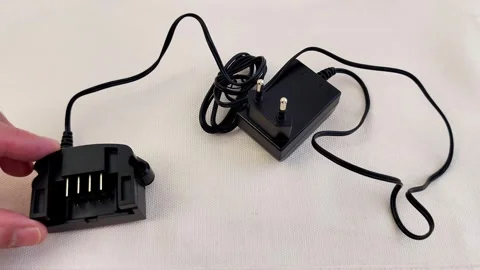 Compact Battery Charger Setup with Power Adapter and Coiled Cord Stock-Footage 321449979
