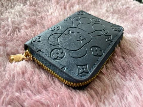 Compact blue wallet with embossed bear pattern Stock Photos