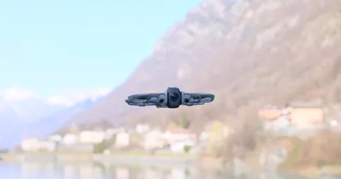 Compact Camera Drone Hovering Over Lakeside Village Stock Footage 343742846