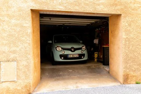 Compact car parked inside open garage Stock Photos