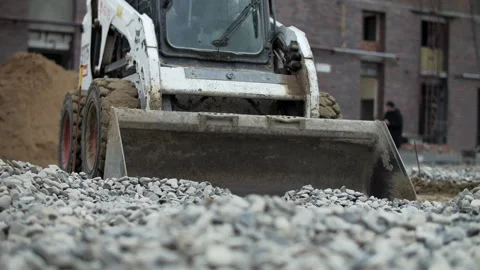 Compact construction loader pushing gravel on building site Stock Footage 326066752