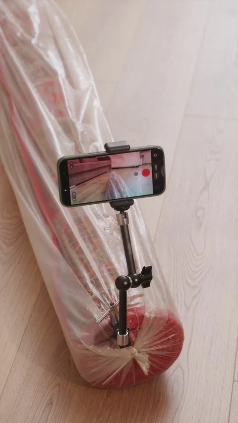 Compact digital camera mounted on magic arm clamp attached to rolled rug Stock-Footage 346396247