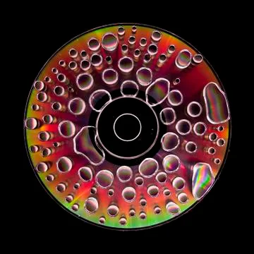 Compact disc cd with water drops on the data surface with a shiny colorful re Stock Photos