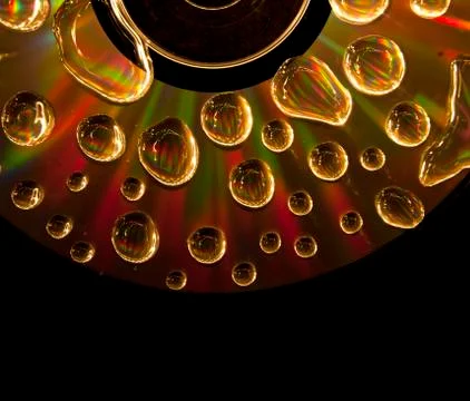 Compact disc cd with water drops on the data surface with a shiny colorful re Stock Photos