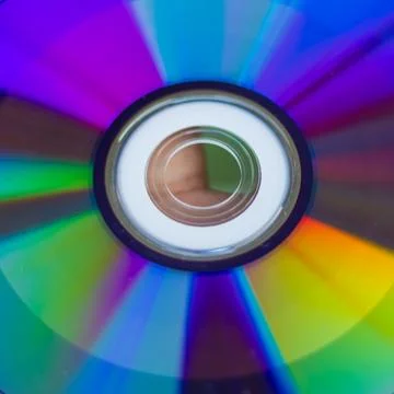 Compact Disc. Holding a CD in hands. The back side of the CD reflects colorfu Stock Photos
