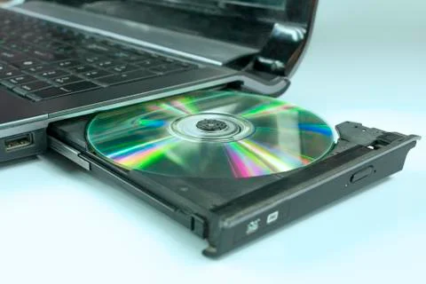 Compact disc inserted in the tray of the SD drive of the notebook on an empty Stock Photos