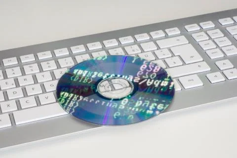 Compact disc with programming code on keyboard 스톡 사진