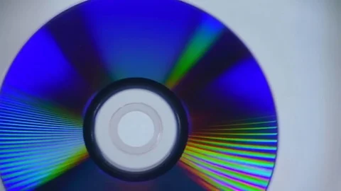 The compact disc rotates on a glossy white glowing surface Stock Footage