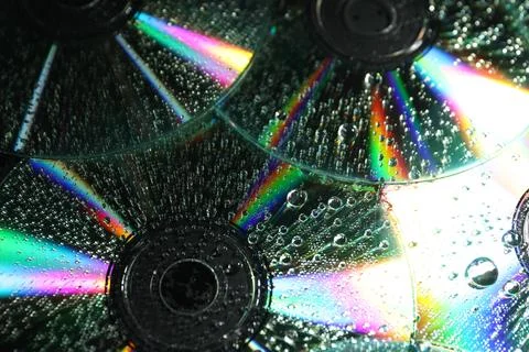 Compact discs with drops as background, closeup Stock Photos