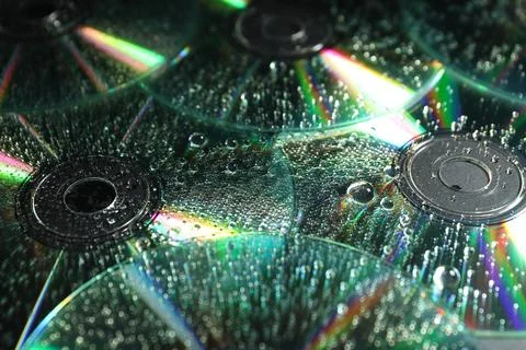 Compact discs with drops as background, closeup Stock Photos