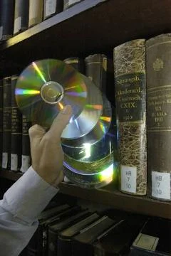 A compact disk (cd) or a dvd in the library compact disk or dvd in the lib... Stock Photos