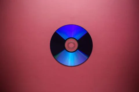 Compact disk close-up on a red burgundy background, outdated data storage Foto stock